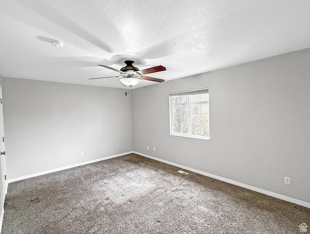 spare room featuring carpet flooring, baseboards, a ceiling fan, and a textured ceiling
