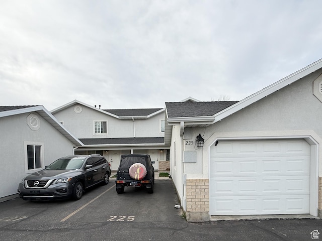 view of front of home featuring a shingled roof and stucco siding