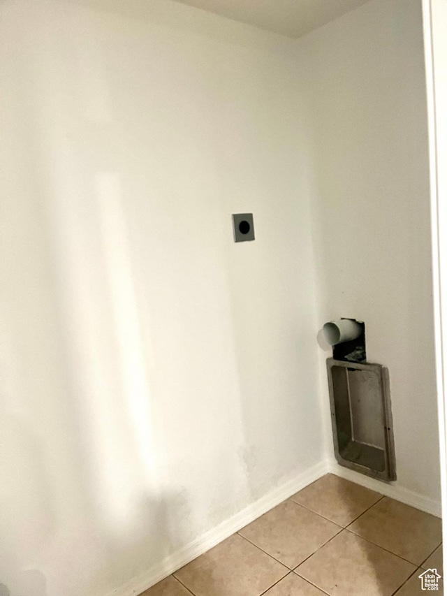 laundry room featuring hookup for an electric dryer, light tile patterned floors, laundry area, and baseboards