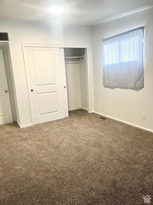 unfurnished bedroom with a closet, baseboards, and carpet flooring