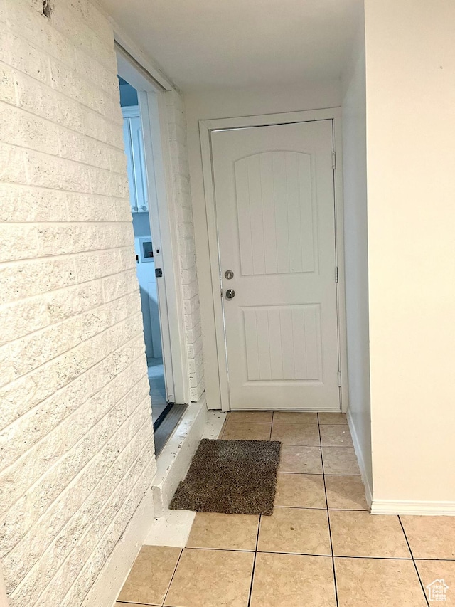 entryway with baseboards and light tile patterned flooring
