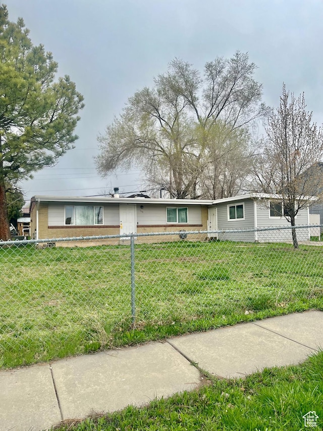 single story home with a front lawn and a fenced front yard