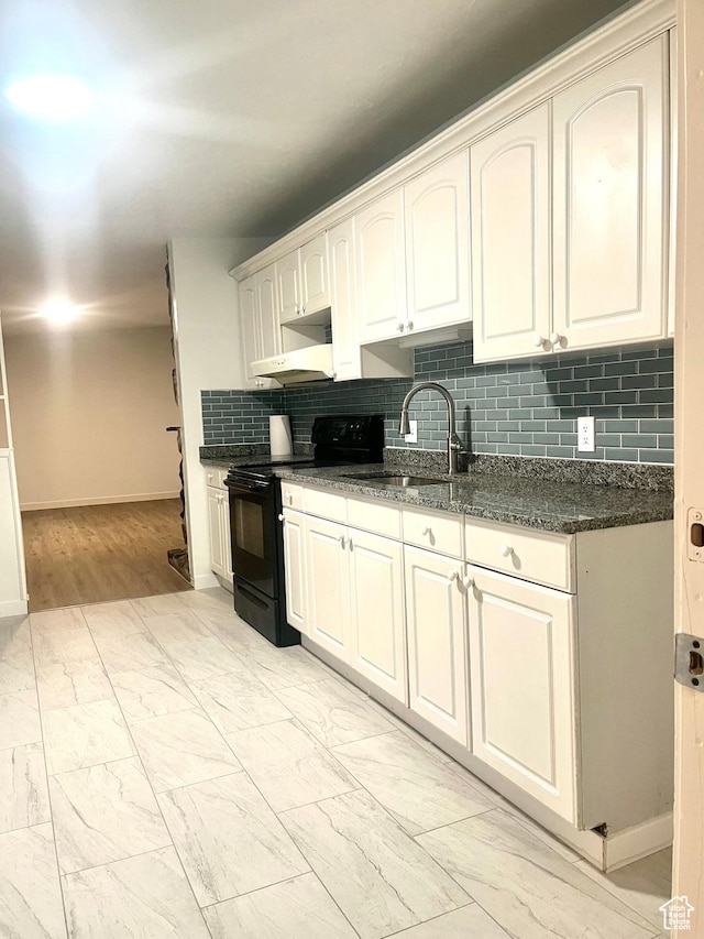 kitchen featuring baseboards, backsplash, black electric range, marble finish floor, and a sink
