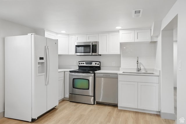1705 E 2700 S, Salt Lake City, UT 84106 - kitchen featuring stainless steel appliances, a sink, light wood-type flooring, white cabinetry, and light countertops