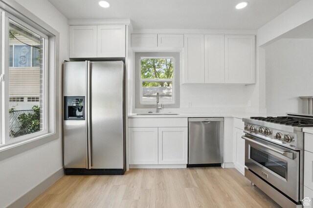 1705 E 2700 S, Salt Lake City, UT 84106 - kitchen featuring stainless steel appliances, a sink, light wood-style flooring, white cabinets, and light countertops