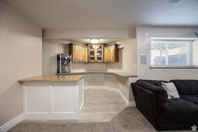2115 N 5 E, Layton, UT 84041 - kitchen with brown cabinets, glass insert cabinets, a textured ceiling, baseboards, and a peninsula
