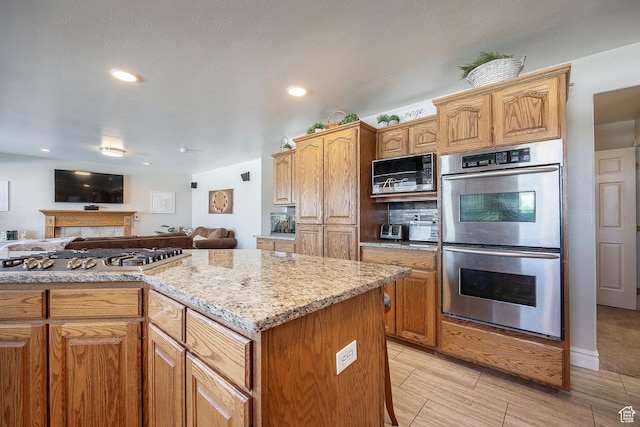 2115 N 5 E, Layton, UT 84041 - kitchen with stainless steel appliances, open floor plan, light stone counters, recessed lighting, and a fireplace