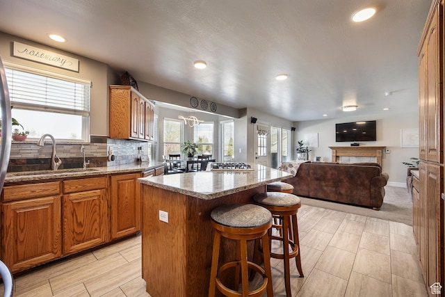 2115 N 5 E, Layton, UT 84041 - kitchen featuring a sink, a center island, a kitchen breakfast bar, open floor plan, and light stone countertops