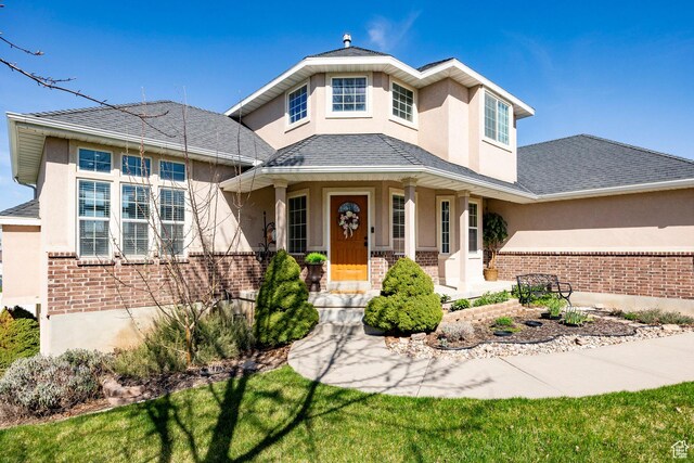 2115 N 5 E, Layton, UT 84041 - view of front of house featuring stucco siding, brick siding, covered porch, and a shingled roof