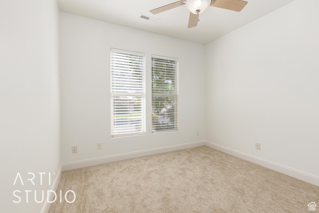 carpeted spare room with visible vents, ceiling fan, and baseboards