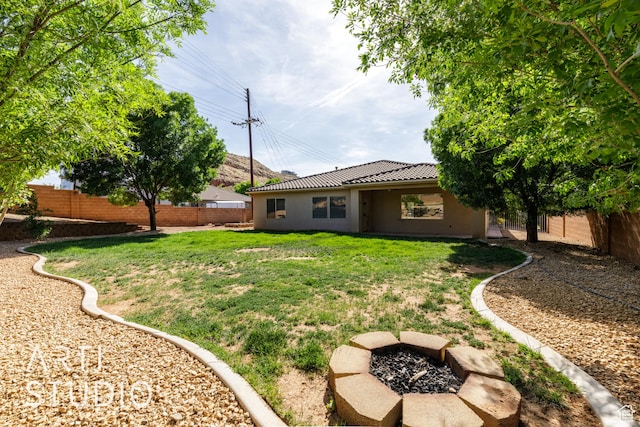 view of yard with a fire pit and a fenced backyard