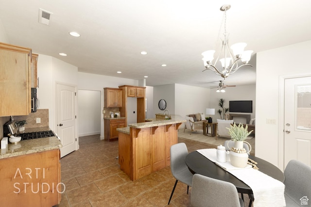 1971 S Great Basin Dr, Washington, UT 84780 - kitchen featuring backsplash, a breakfast bar, ceiling fan, a chandelier, and recessed lighting