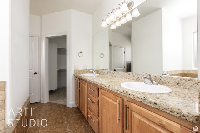 full bath with tile patterned flooring, double vanity, a sink, and a spacious closet