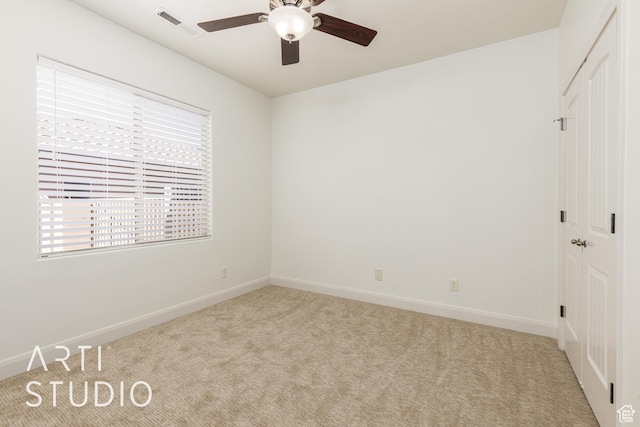 interior space with a closet, visible vents, multiple windows, and light colored carpet