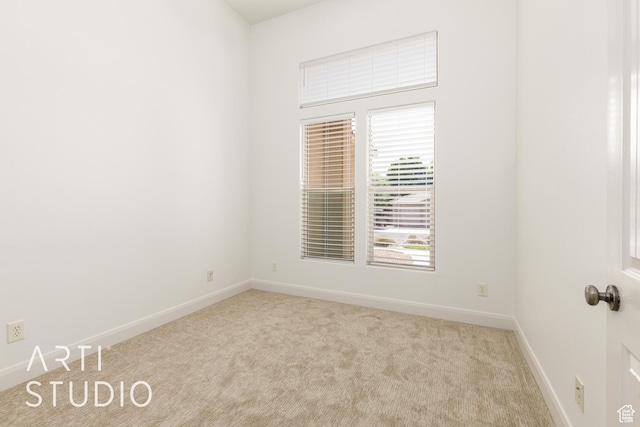 carpeted empty room featuring baseboards