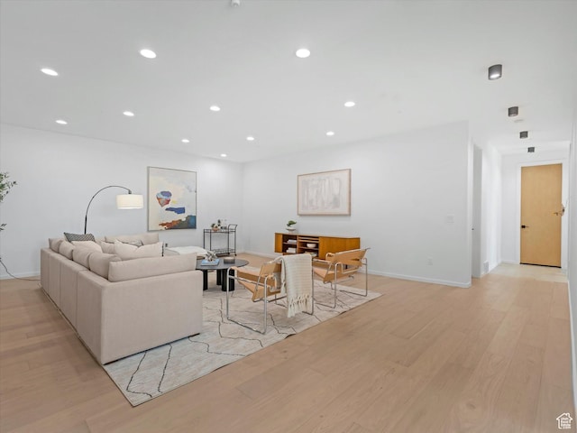living area with light wood-style flooring, recessed lighting, and baseboards