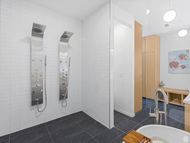 full bathroom featuring tile patterned flooring, a tile shower, and tile walls