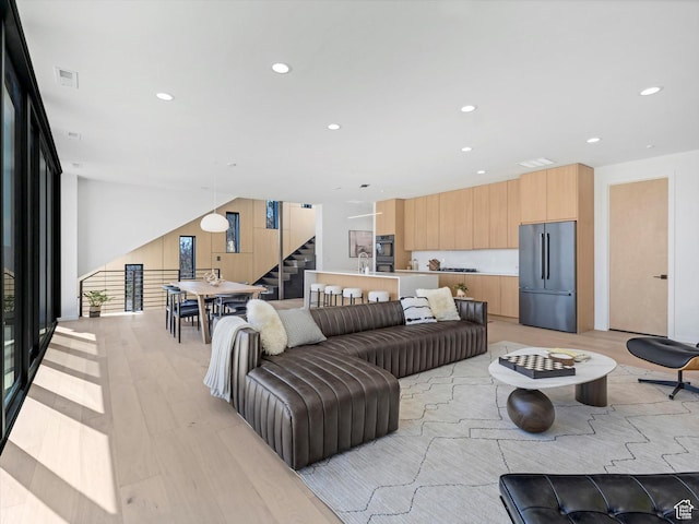 living room featuring stairway, recessed lighting, and light wood-style flooring