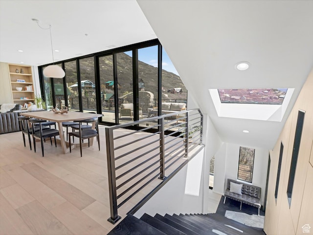 staircase with wood finished floors, a skylight, recessed lighting, and a mountain view