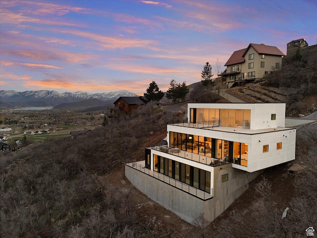 back of property with a balcony and a mountain view