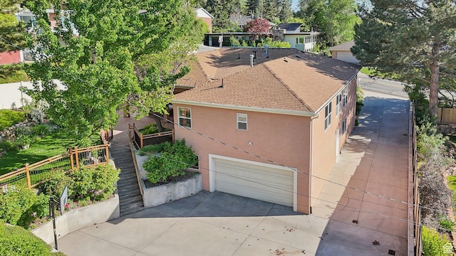 3391 E Brockbank Dr S, Millcreek, UT 84124 - view of side of property featuring stucco siding, a garage, and driveway