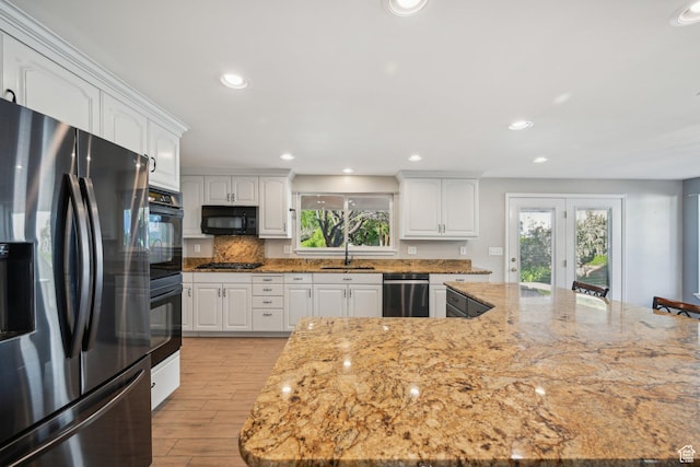 3391 E Brockbank Dr S, Millcreek, UT 84124 - kitchen with black appliances, a sink, light wood finished floors, white cabinetry, and light stone countertops