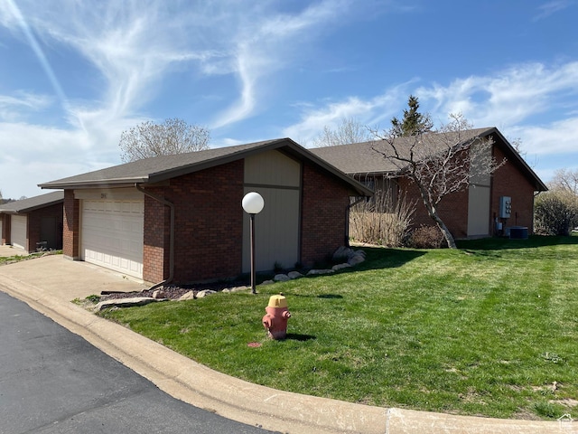 2547 E 1900 N, Layton, UT 84040 - view of side of property with a garage, central air condition unit, a yard, brick siding, and concrete driveway