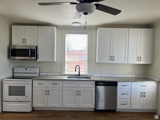 kitchen with ceiling fan, white cabinets, dark wood-style flooring, a sink, and stainless steel appliances