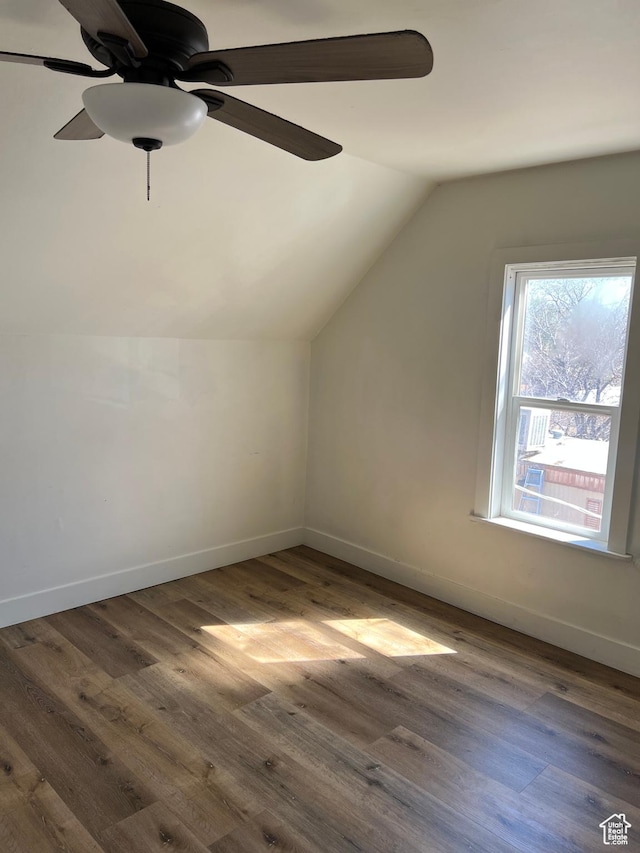 bonus room featuring dark wood-style floors, baseboards, a ceiling fan, and lofted ceiling