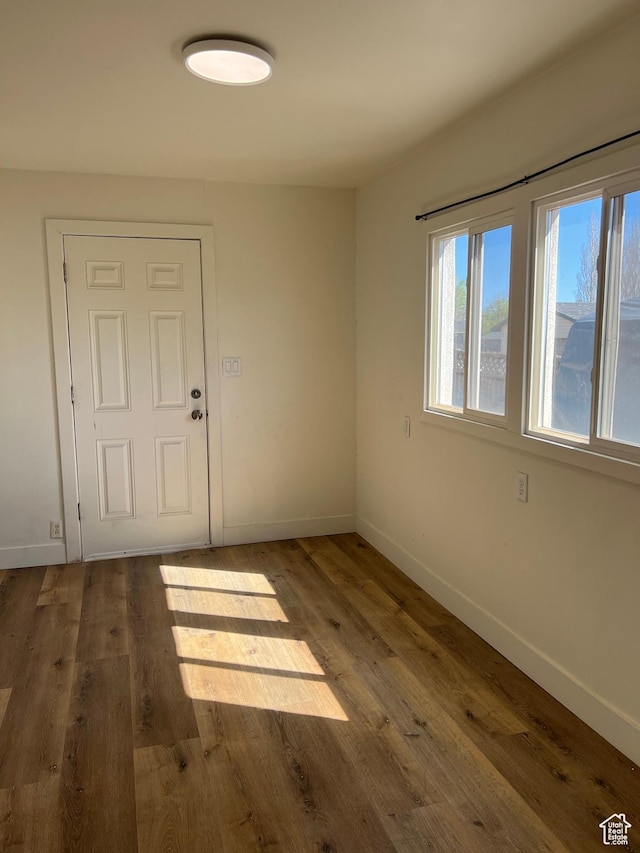 empty room with baseboards and wood finished floors