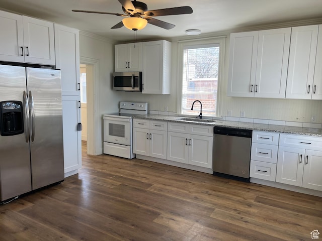 kitchen with white cabinets, dark wood-style floors, a sink, and appliances with stainless steel finishes