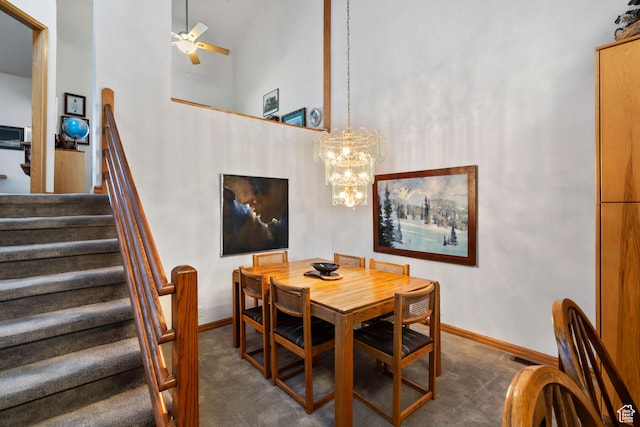4042 Saddleback Rd, Park City, UT 84098 - dining space with ceiling fan with notable chandelier, a towering ceiling, stairs, dark colored carpet, and baseboards