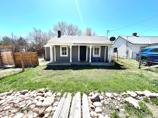 bungalow featuring a chimney, fence, a front lawn, and covered porch