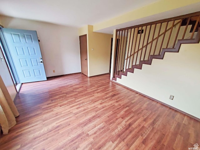 281 E 7th St S, Ogden, UT 84404 - unfurnished living room featuring light wood-type flooring, baseboards, and stairway