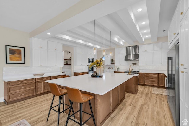 1816 S 920 W, Hurricane, UT 84737 - kitchen with brown cabinetry, tasteful backsplash, wall chimney range hood, and a spacious island