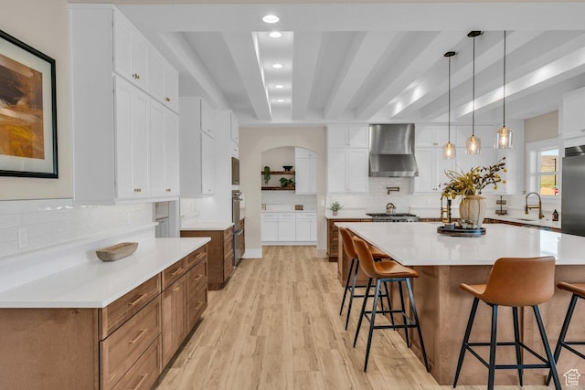 1816 S 920 W, Hurricane, UT 84737 - kitchen with light wood finished floors, a sink, wall chimney range hood, and a kitchen breakfast bar