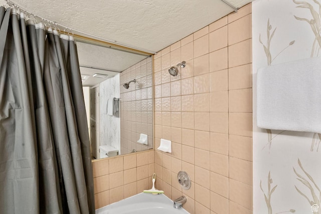 full bath featuring a textured ceiling and shower / tub combo