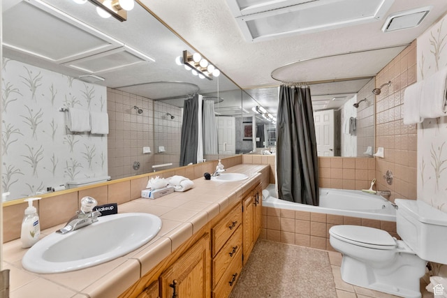 bathroom with tile patterned flooring, a sink, tiled shower / bath, and toilet