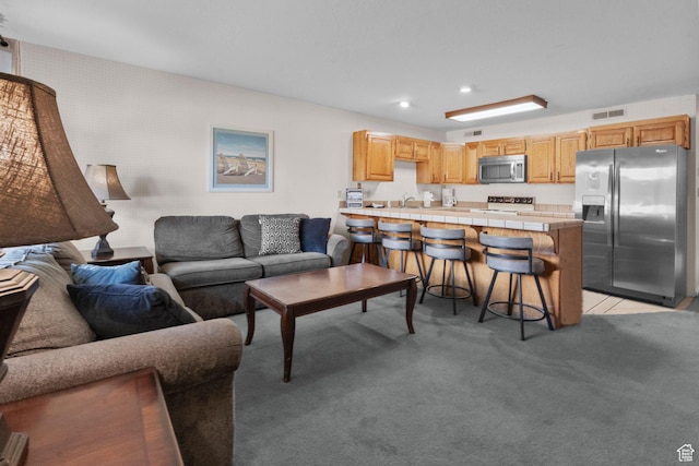 living area with visible vents, wallpapered walls, recessed lighting, and light colored carpet