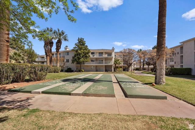 surrounding community with a residential view, a yard, and shuffleboard