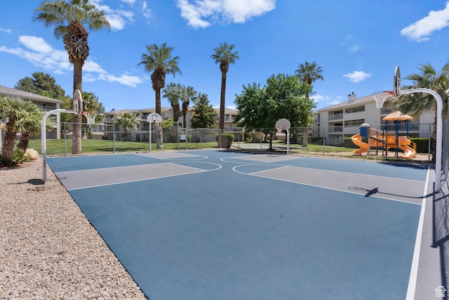 view of sport court featuring community basketball court, fence, and playground community