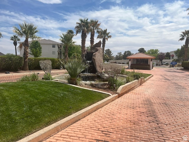 exterior space with a gazebo, decorative driveway, and a yard