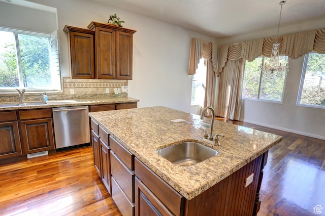 kitchen featuring dishwasher, hardwood / wood-style flooring, a sink, and visible vents
