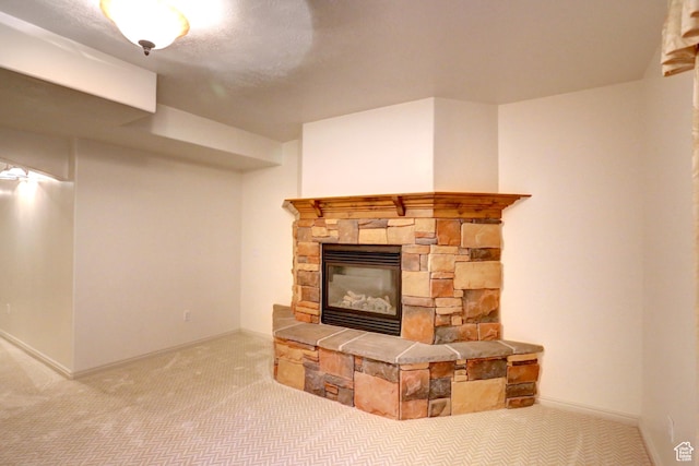 unfurnished living room with carpet flooring, baseboards, and a stone fireplace