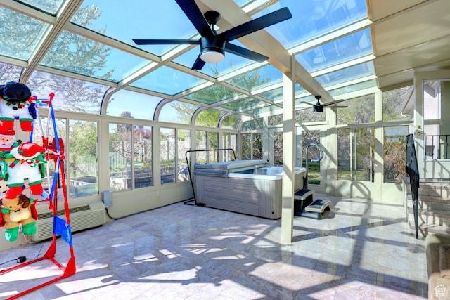sunroom featuring a wealth of natural light, a ceiling fan, and a hot tub