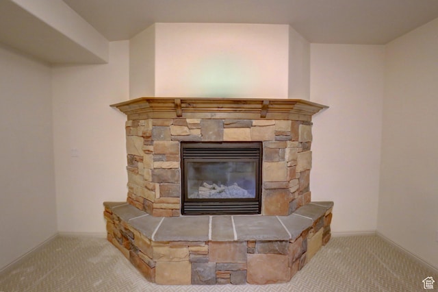 room details featuring baseboards, a stone fireplace, and carpet