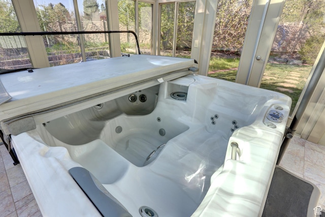 exterior space featuring a jacuzzi and a healthy amount of sunlight
