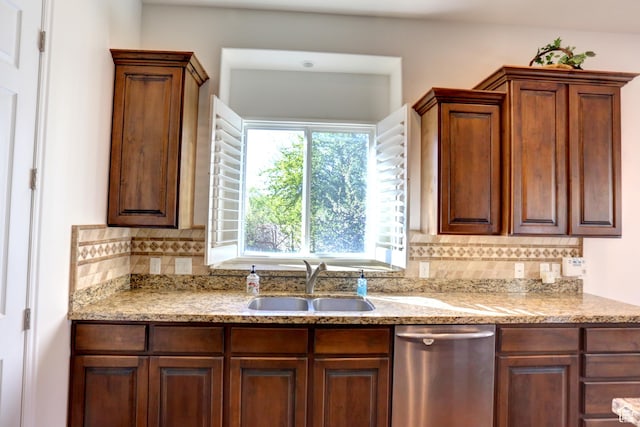 kitchen with tasteful backsplash, light stone countertops, dishwasher, and a sink