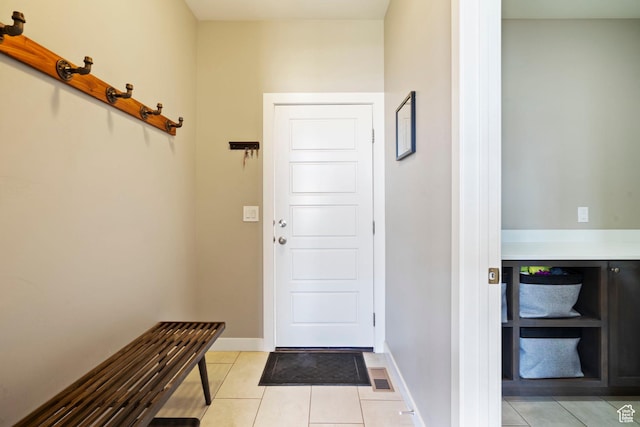 doorway to outside with light tile patterned floors, visible vents, and baseboards