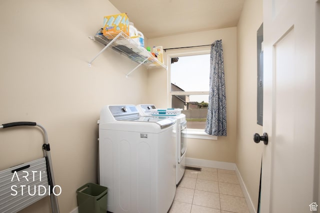 washroom with light tile patterned floors, independent washer and dryer, laundry area, and baseboards